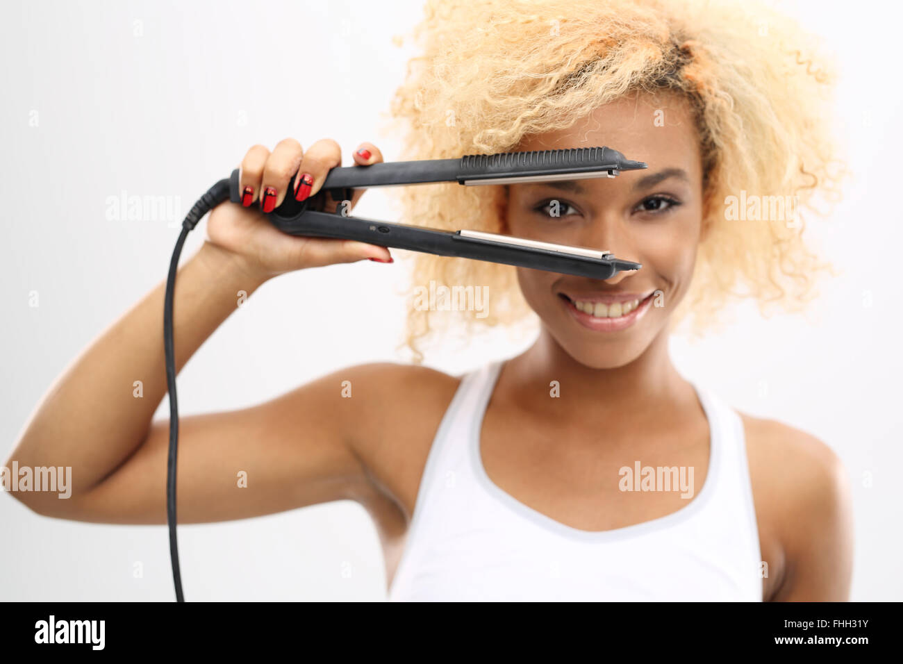 Laying hair straightener or curling iron. Young girl straightens her