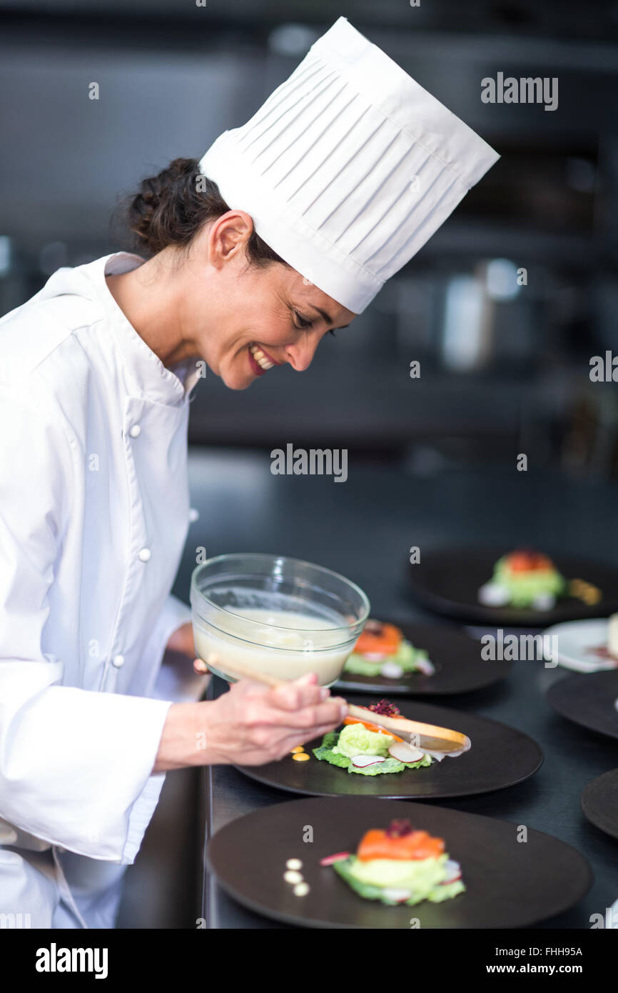 Happy chef finishing her dishes Stock Photo