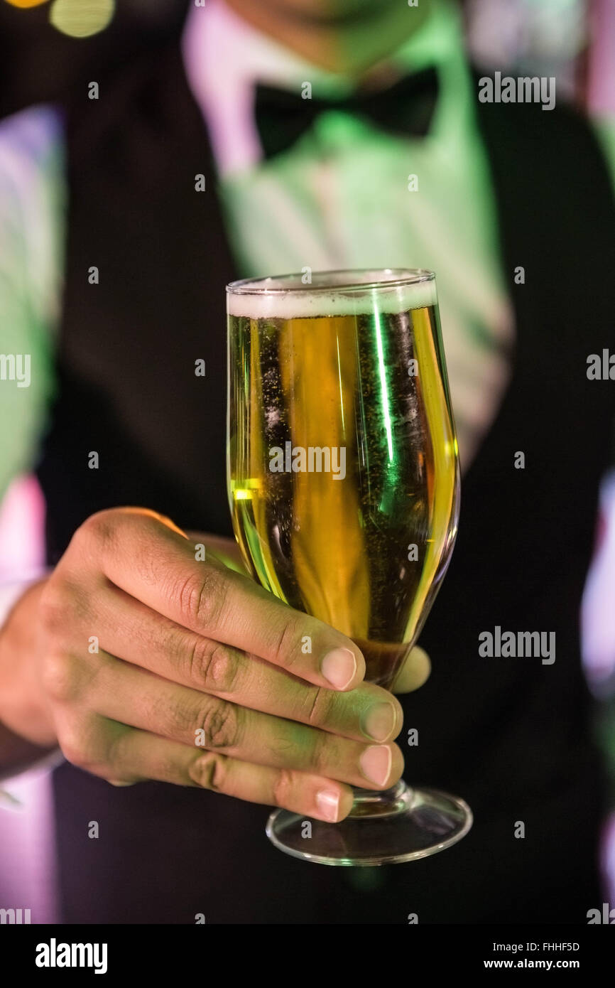 Close-up of bartender serving glass of beer Stock Photo