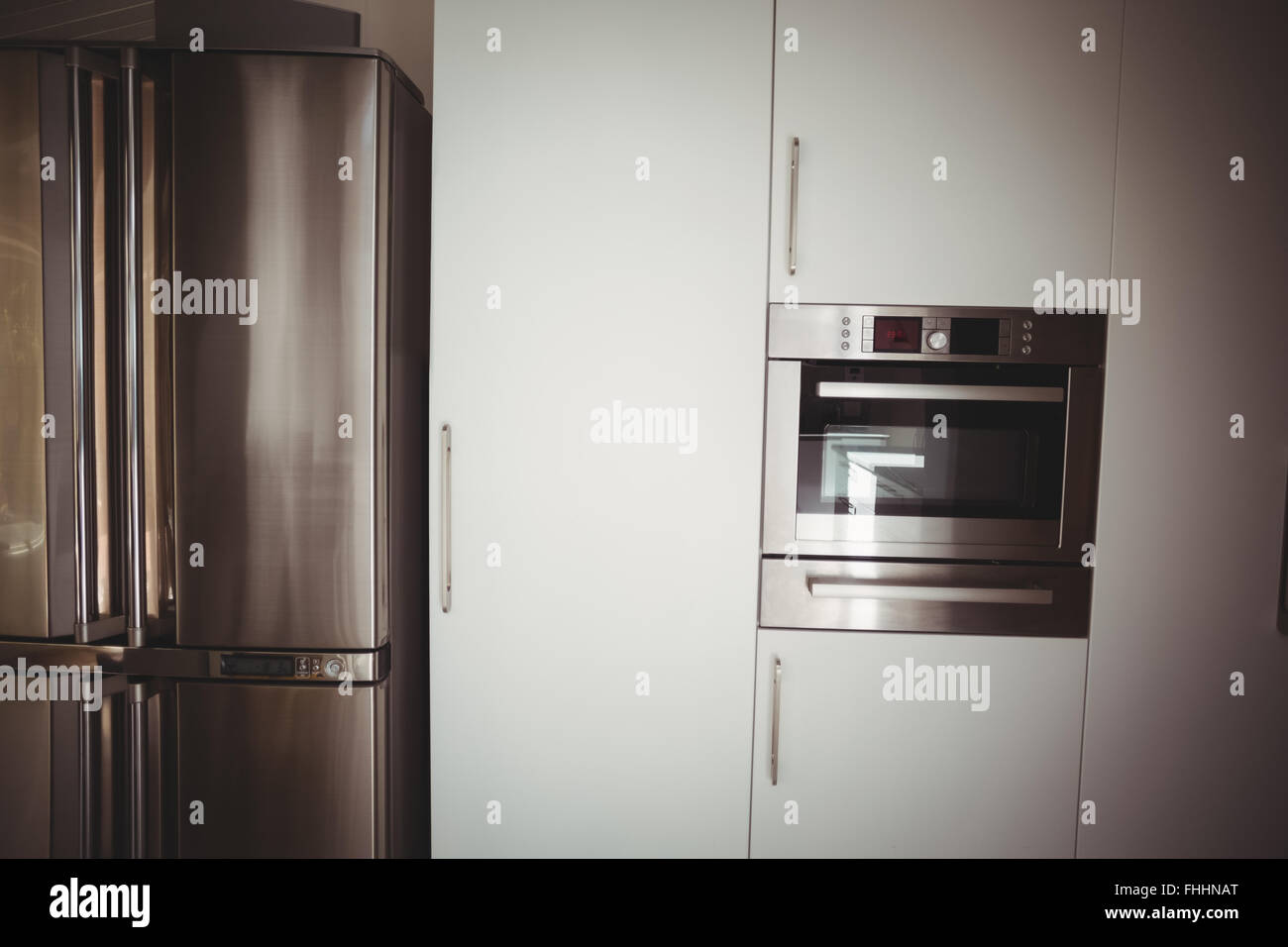 Fridge and oven in stylish kitchen Stock Photo - Alamy