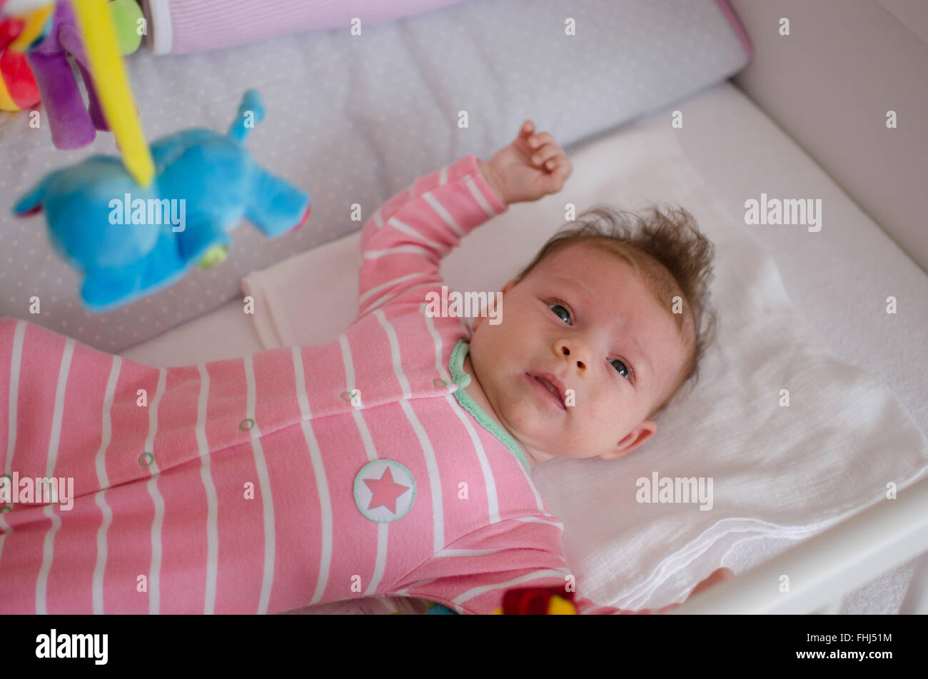 little cute baby girl playing in a cot Stock Photo Alamy