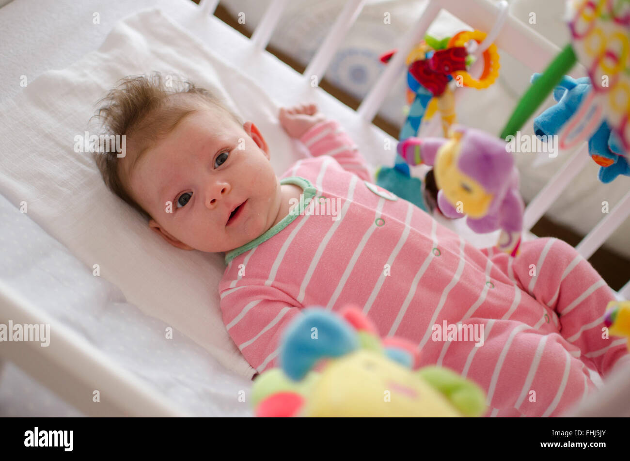 little cute baby girl playing in a cot Stock Photo Alamy