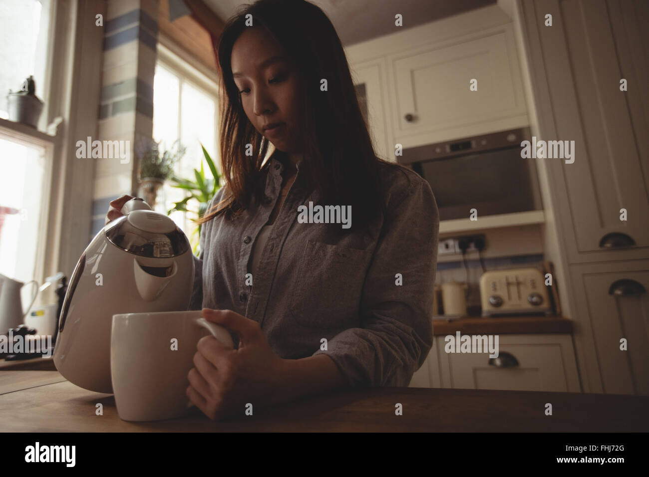 pouring water in her mug Stock Photo Alamy