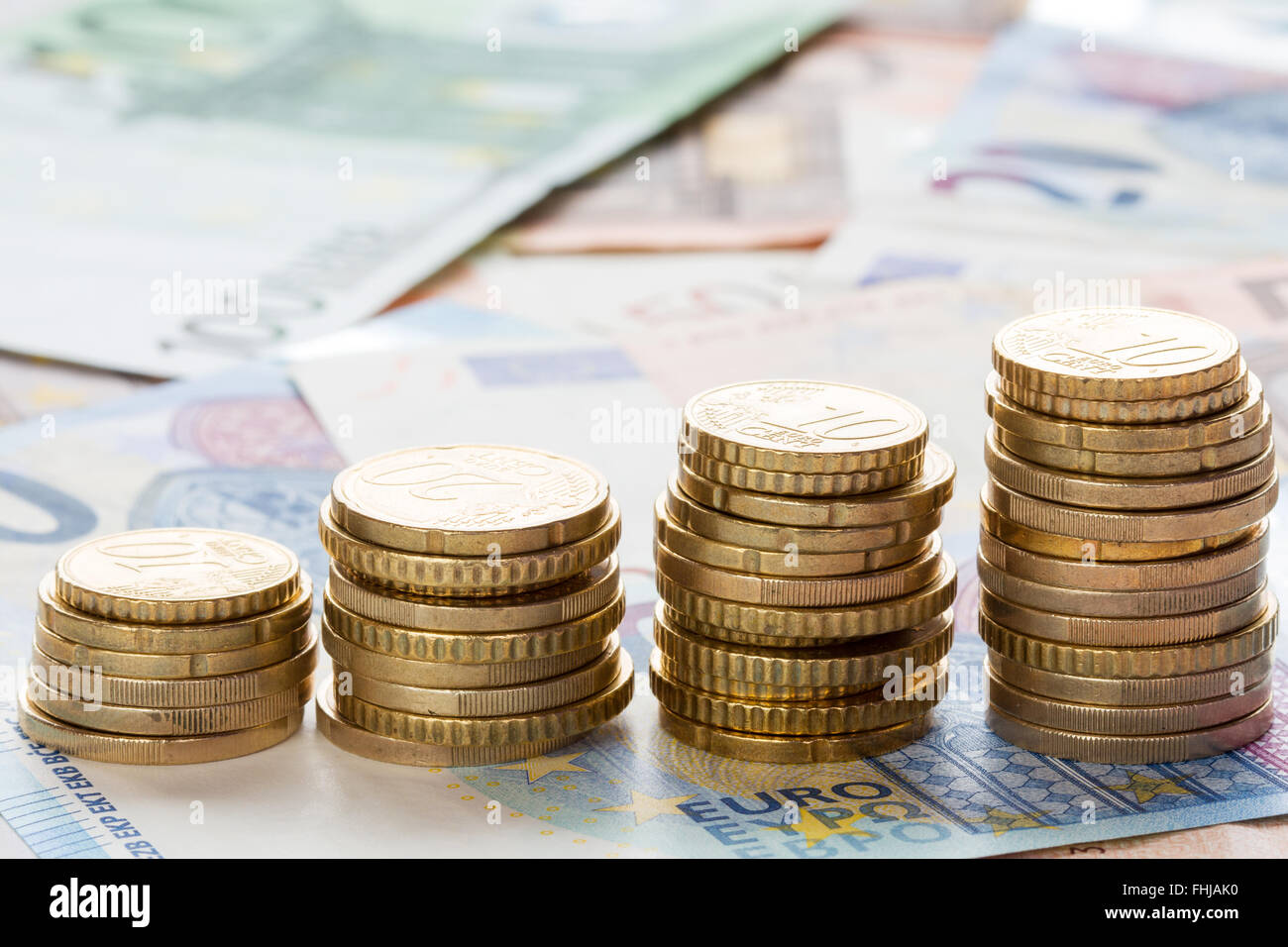 Stack of ascending Euro coins on banknote money background Stock Photo ...