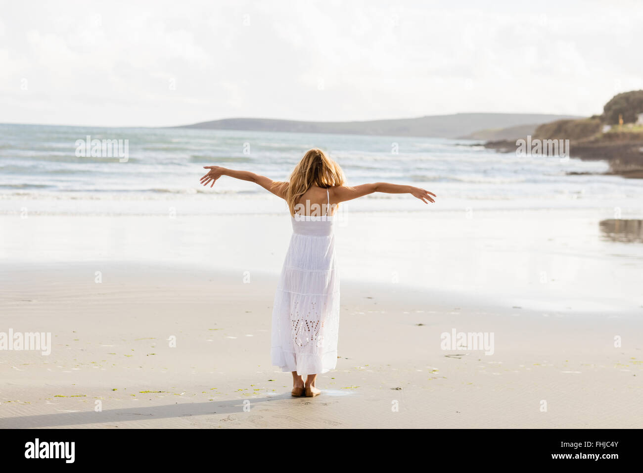 Beautiful blonde woman with arms outstretched Stock Photo
