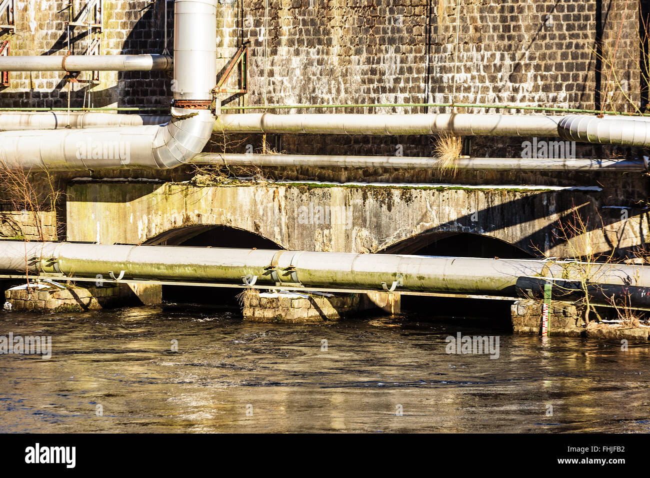 Two tunnels under a dam work as water outlet. Different pipes visible all  over the wall. Detail of a water dam of an abandoned p Stock Photo - Alamy