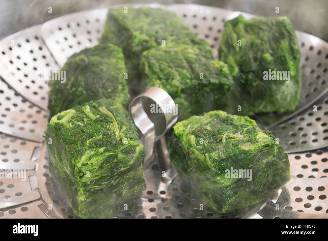 frozen spinach steamed in the metal steamer Stock Photo Alamy