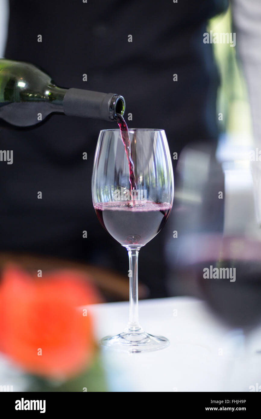 Waiter pouring a glass of red wine Stock Photo