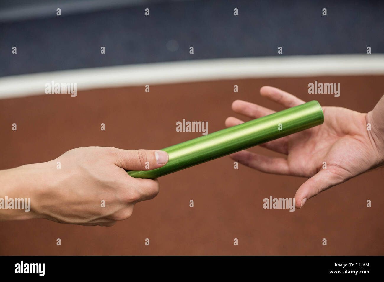 Man passing the baton to partner on track Stock Photo Alamy