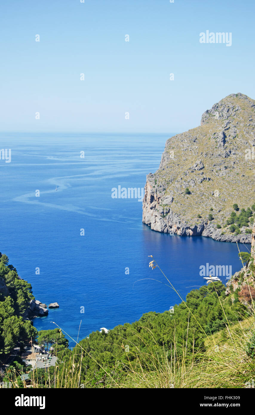 Mallorca, Majorca, Balearic Islands, Spain, Europe: a glimpse of the Mediterranean sea and a beach seen from the winding road leading in Cala Tuent Stock Photo