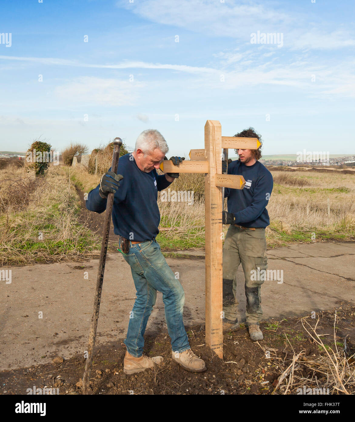 East Sussex County Council Rangers erecting a new public footpath signpost. Stock Photo