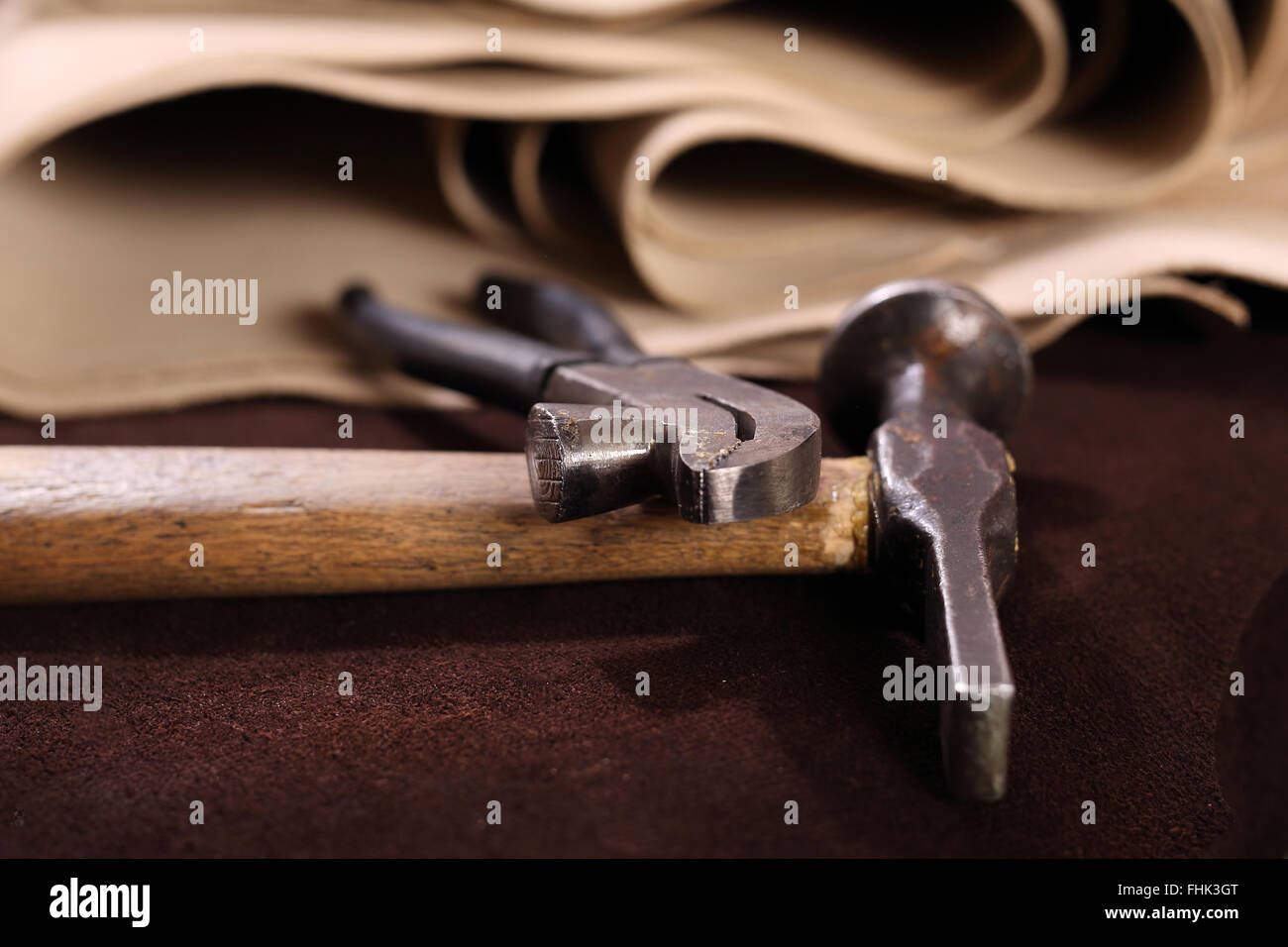 Punch leather for shoes. Hammer and chisel to punch skin. Shoemaker