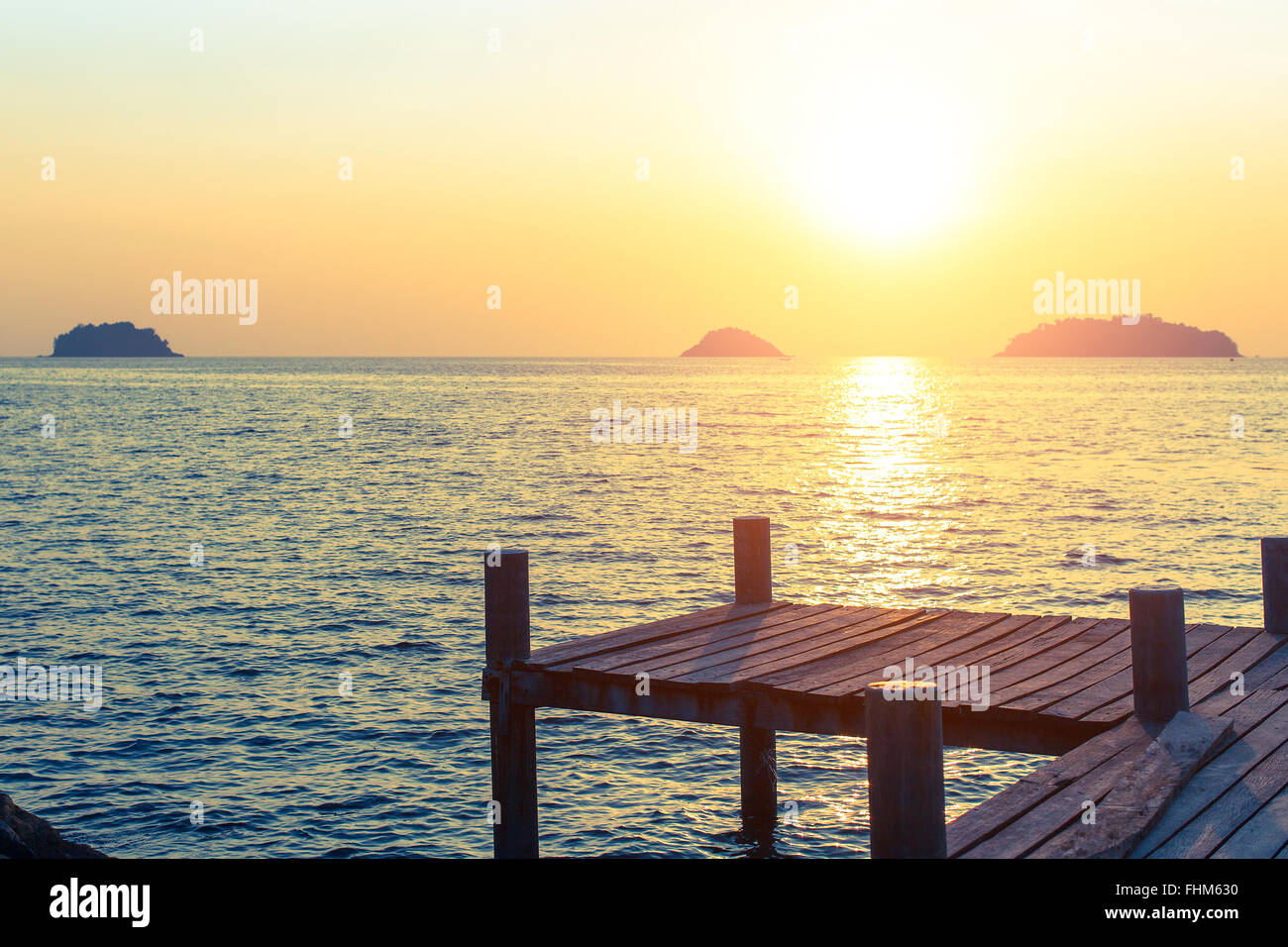 Wooden walkway on the sea coast during sunset. Stock Photo