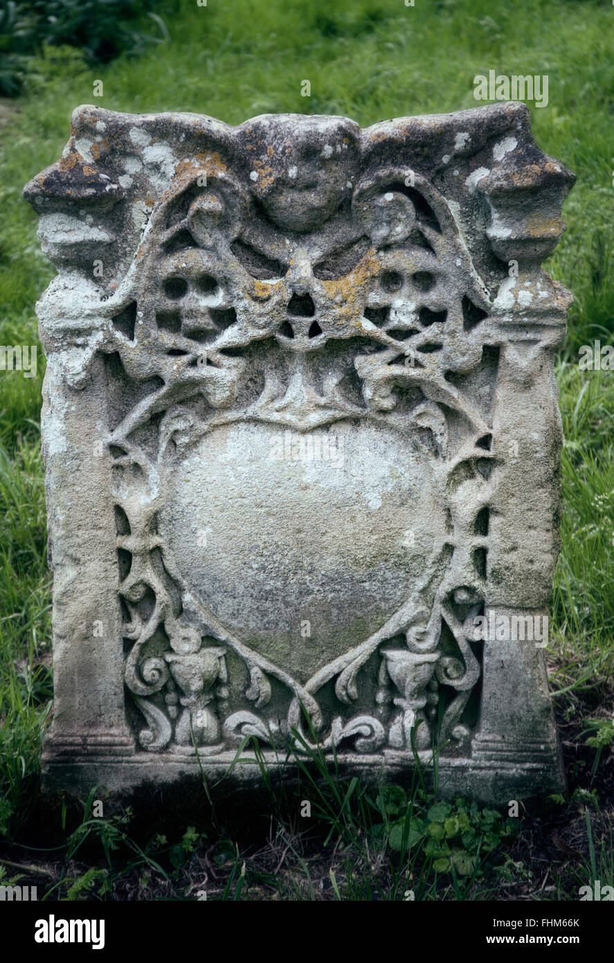 Old gravestone carved with skulls and cross bones. Stock Photo