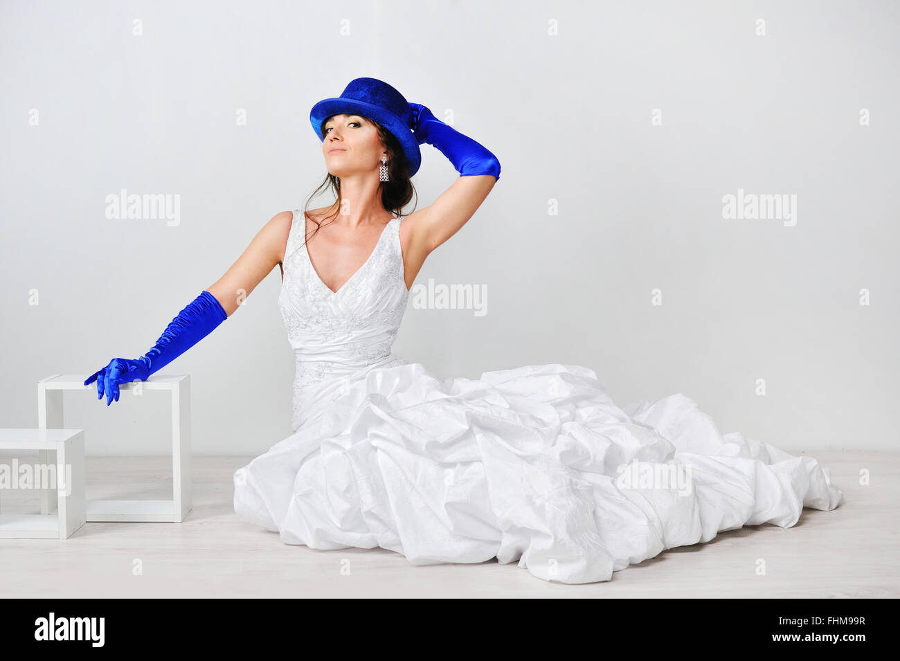 Beautiful girl in a white dress with a blue hat on a white background Stock Photo