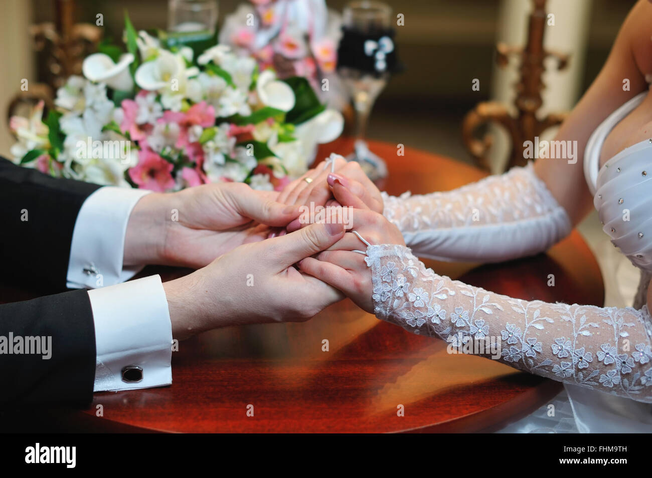 groom holds his bride's hand Stock Photo