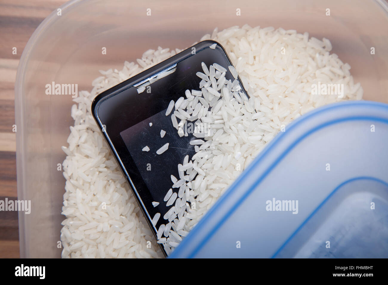 Using uncooked rice to draw out moisture from a mobile phone Stock