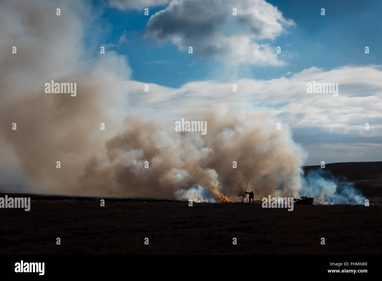 Gamekeeper undertaking a controlled heather burn on Ilkley moor, Yorkshire, UK Stock Photo