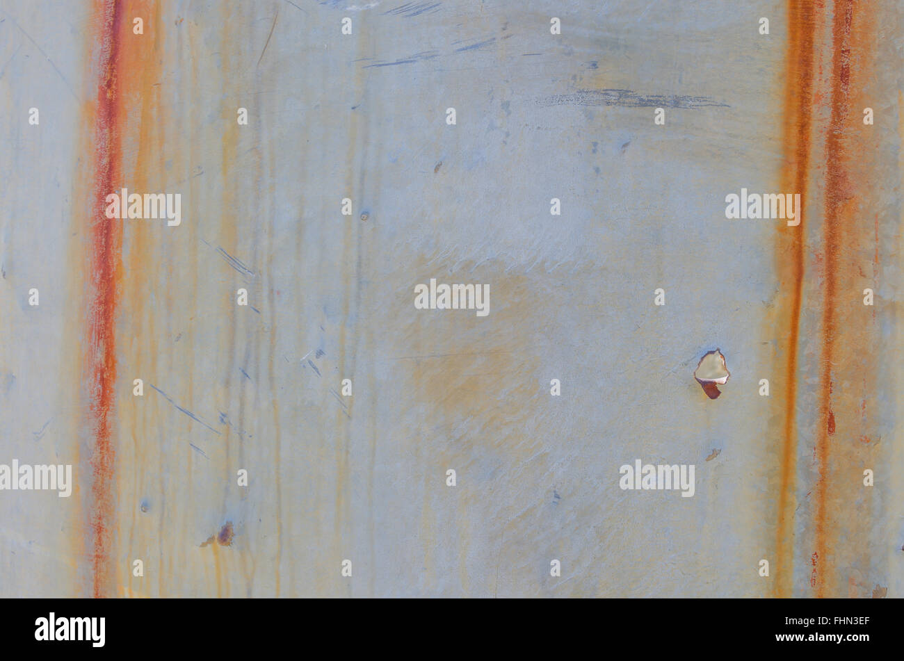 Vertical streaks of rust and bullet hole on sheet metal at an old mill Stock Photo
