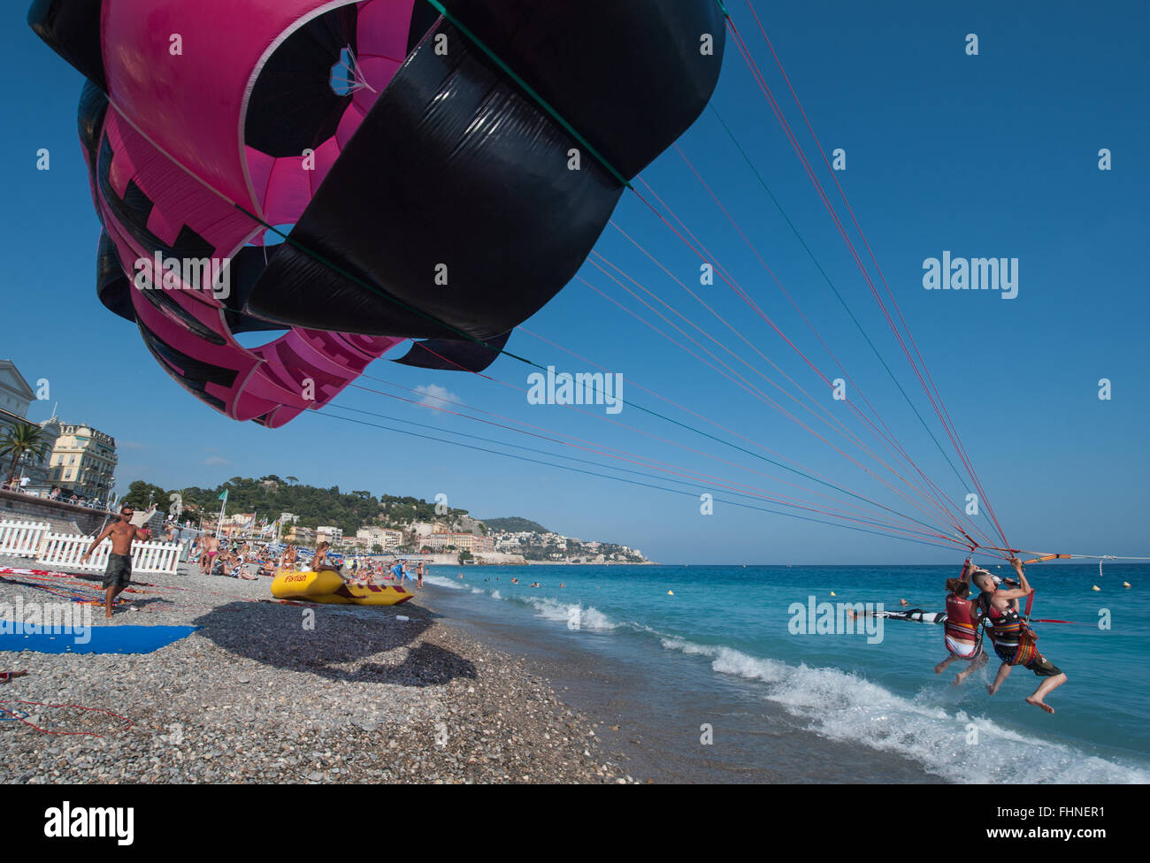 Two people paragliding from the beach at Nice Stock Photo - Alamy