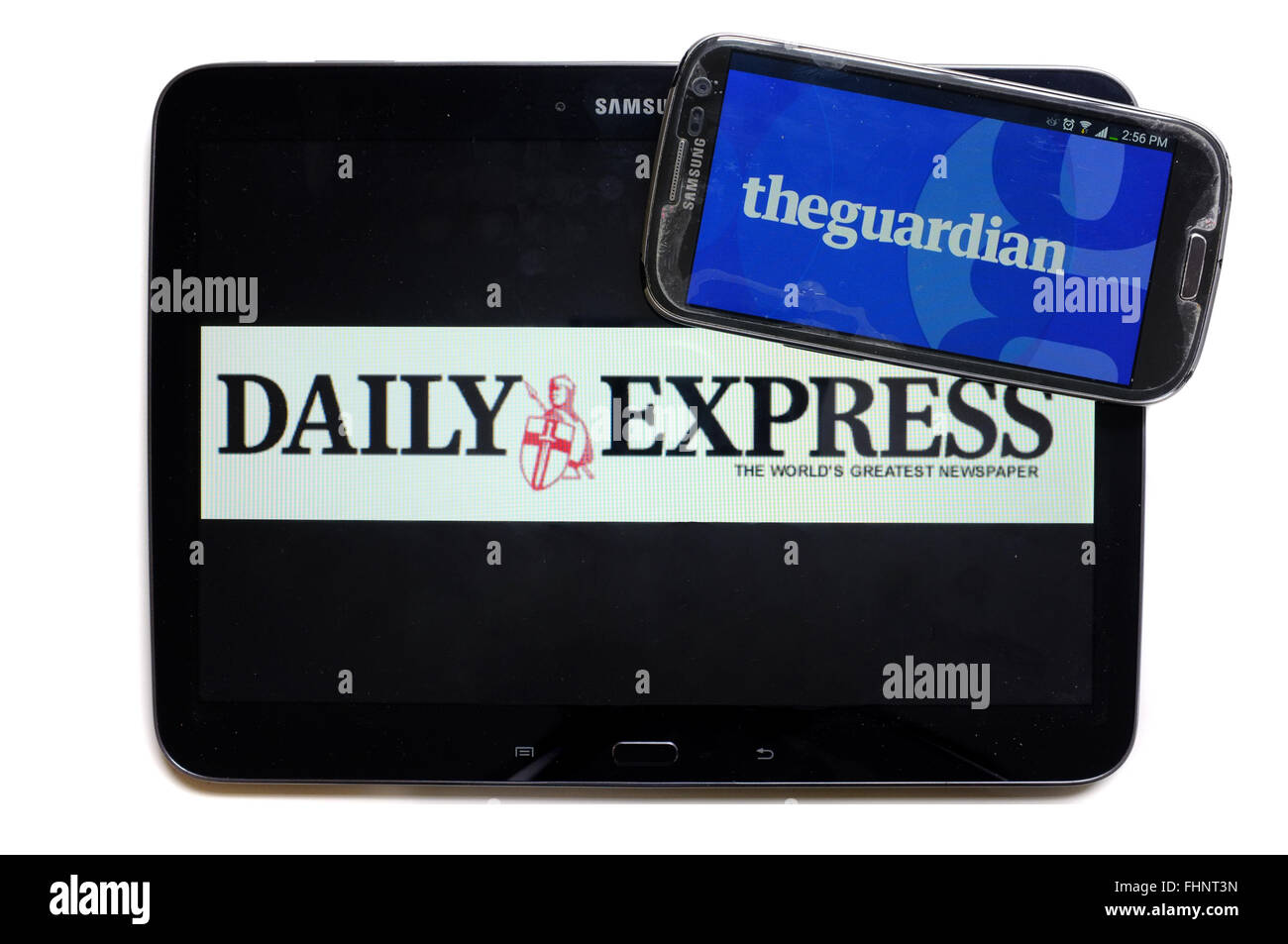 The logos of the Daily Express and The Guardian newspapers displayed on the screens of a tablet and a smartphone. Stock Photo