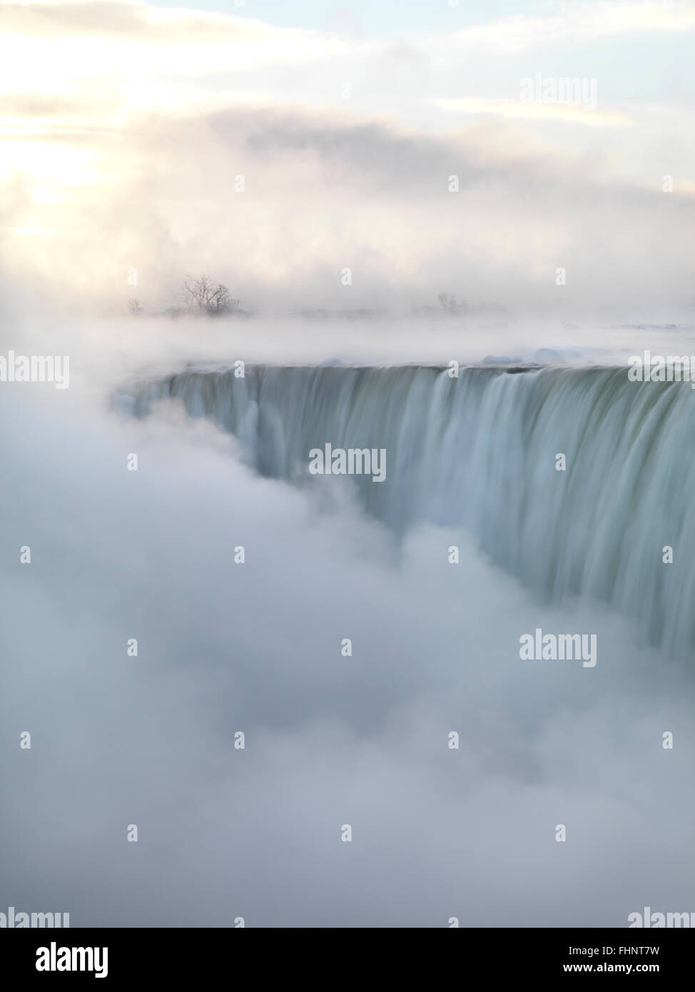 Niagara Falls covered in thick white mist, Canadian Horseshoe, beautiful sunrise scenery in soft light pastel colors, wintertime Stock Photo