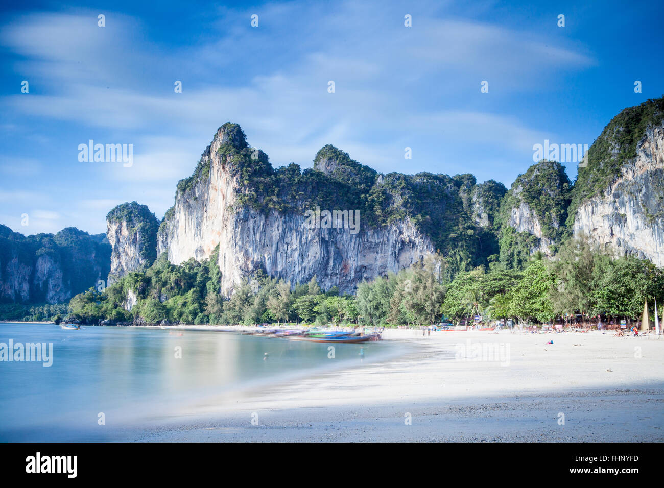 Long exposure image of Railay Beach with picturesque limestone cliffs in that line the white beach. Stock Photo