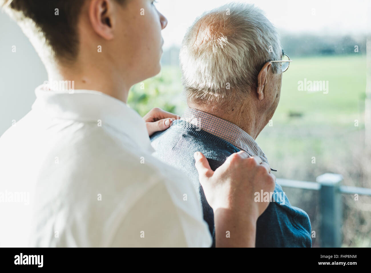 Back view of senior man and his  geriatric nurse Stock Photo