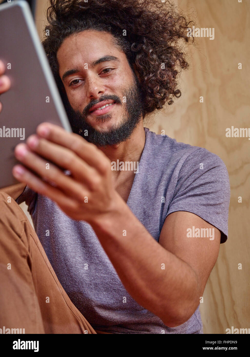 Smiling young man looking at digital tablet Stock Photo
