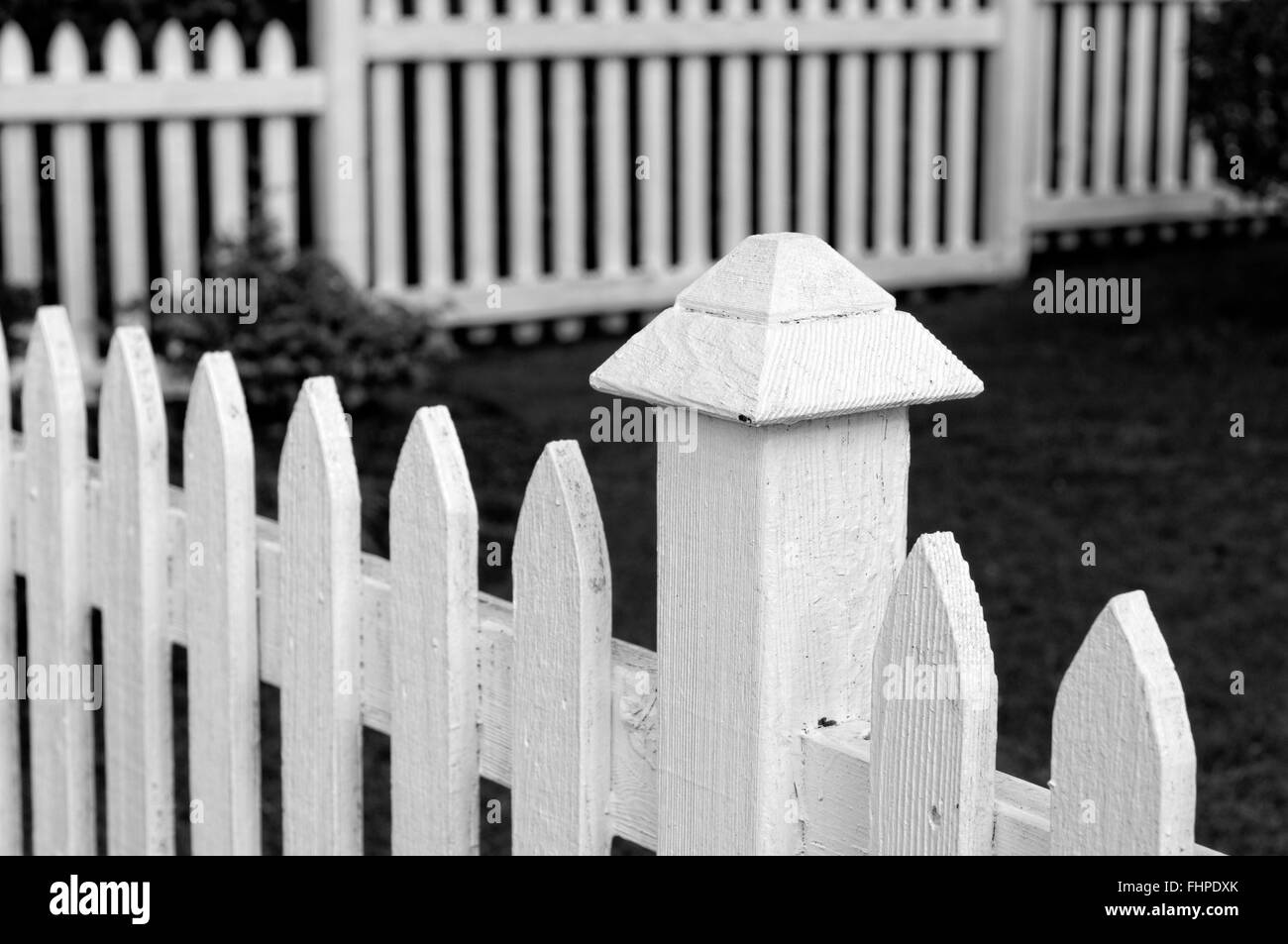 White picket fence surrounding a yard Stock Photo