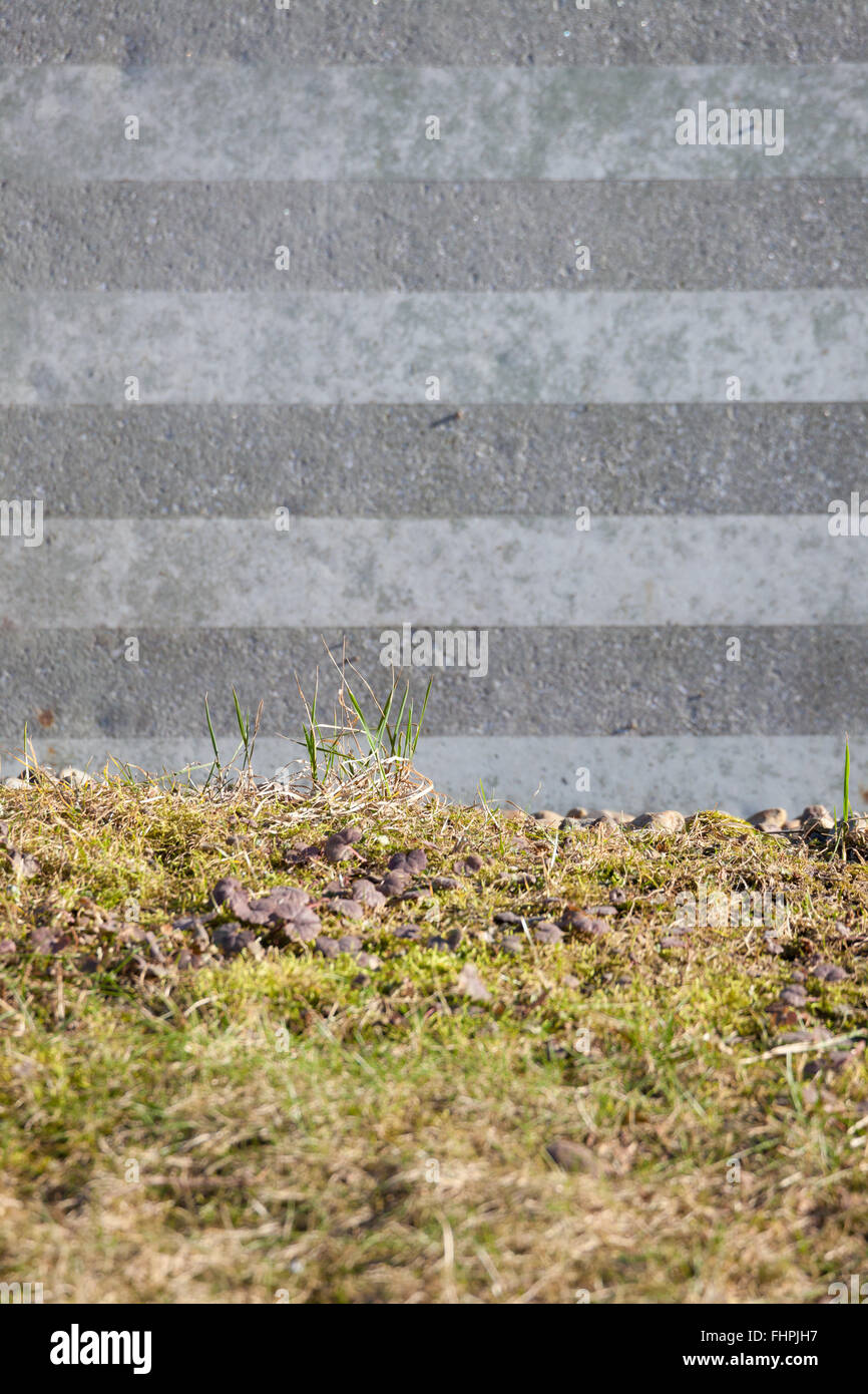 Striped stone wall and grass background Stock Photo - Alamy