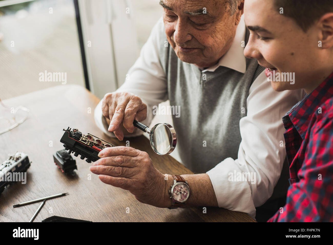 Senior man and grandson with toy train at home Stock Photo