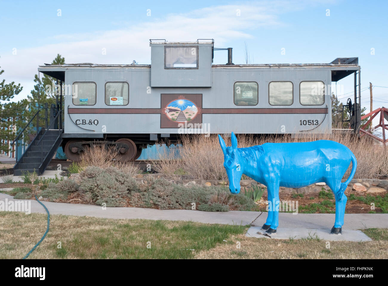 A caboose houses the Chamber of Commerce in Carrizozo  Outside is one of many painted burros that can be found throughout town. Stock Photo