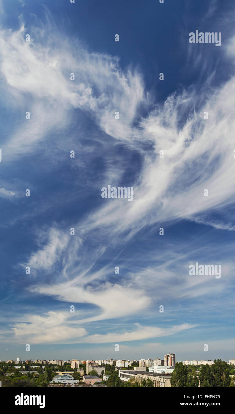 Vertical panorama of a skyline over an industrial area of Bucharest, taken in a beautiful sunny day. Cirrus cloud formation with interesting shapes. Stock Photo