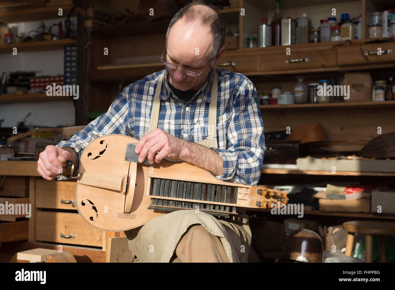 Wittenberg, Germany. 19th Jan, 2016. Musical instruments builder Joerg Dahms at work in his workshop for historical instruments in Wittenberg, Germany, 19 January 2016. The sound of historical instruments is nearly vanished. Hardly anybody still builds them, only few can play them. Joer Dahms can do both. He loves old plucking and string instruments and works with them every day. Photo: Peter Endig/dpa/Alamy Live News Stock Photo