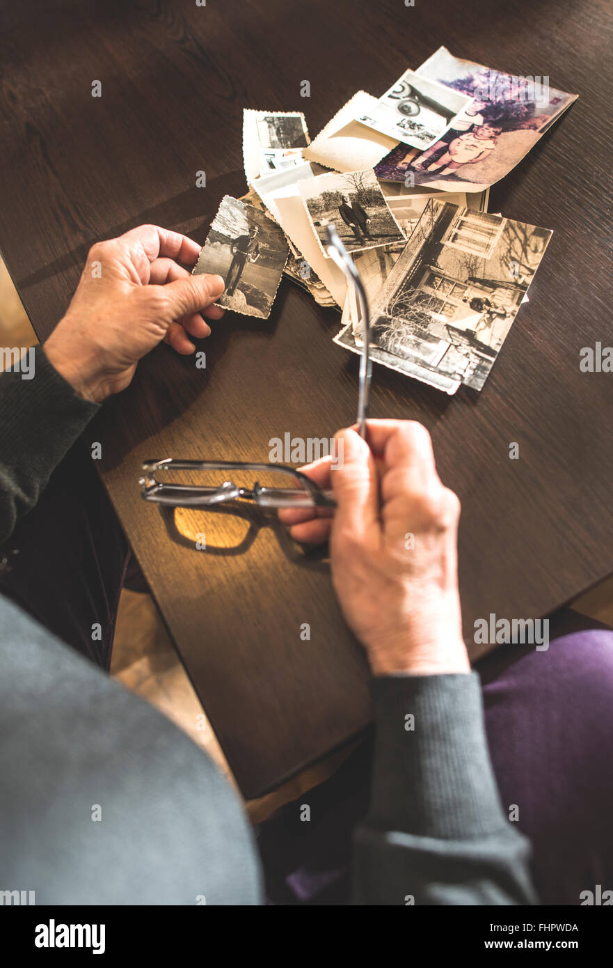 Hands of senior woman holding old photography and spectacles Stock Photo