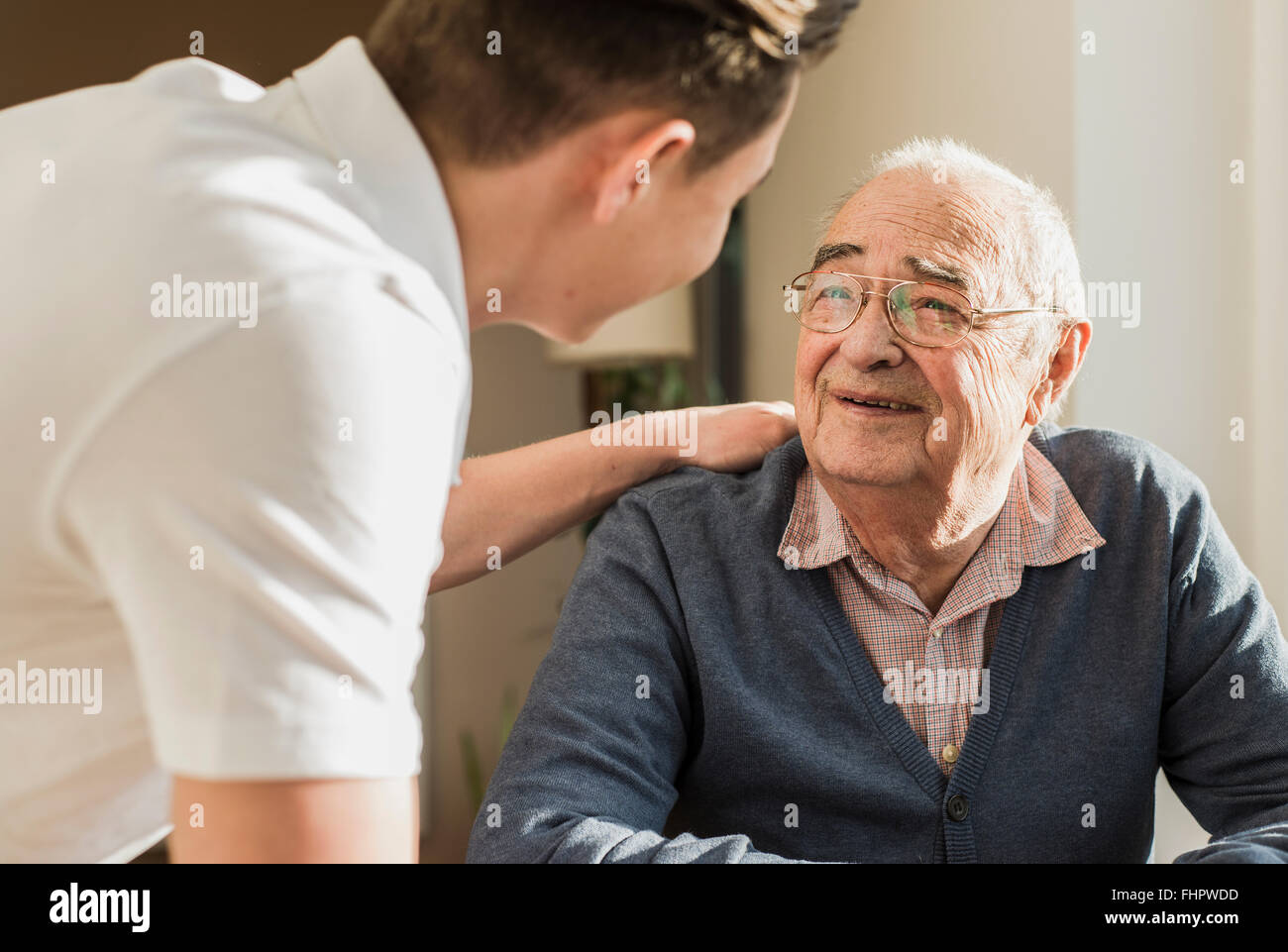 Portrait of smiling senior man face to face with his geriatric nurse Stock Photo
