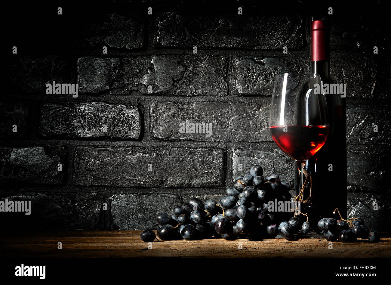 Bunch of grapes and wine on a black brick background Stock Photo