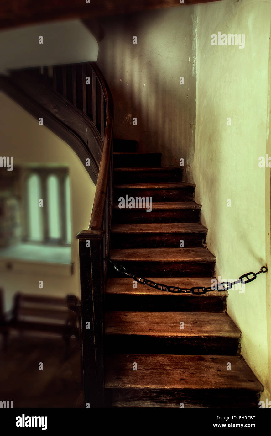 Old staircase wit a chain blocking the way up Stock Photo