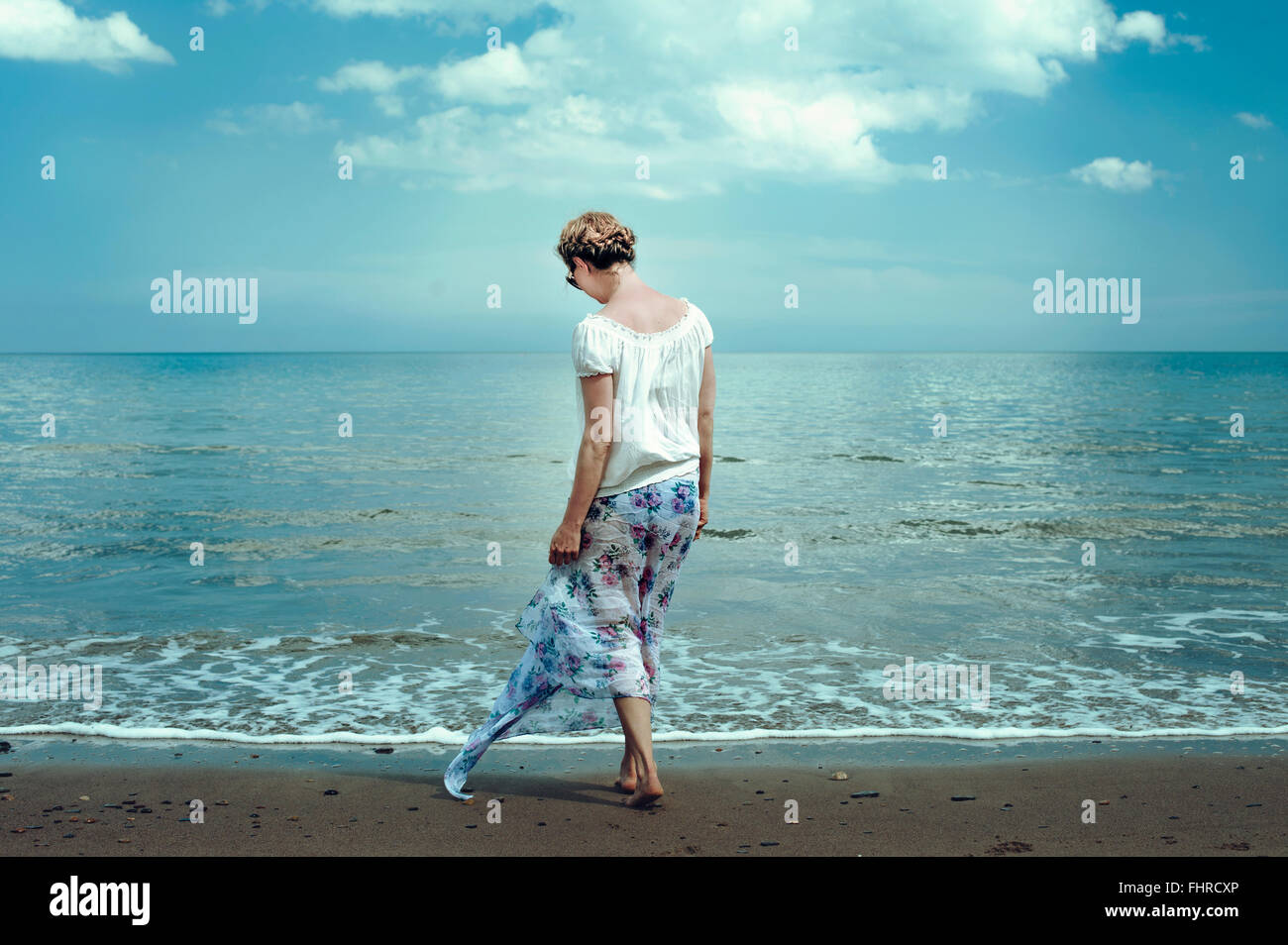 young woman walking on the beach Stock Photo