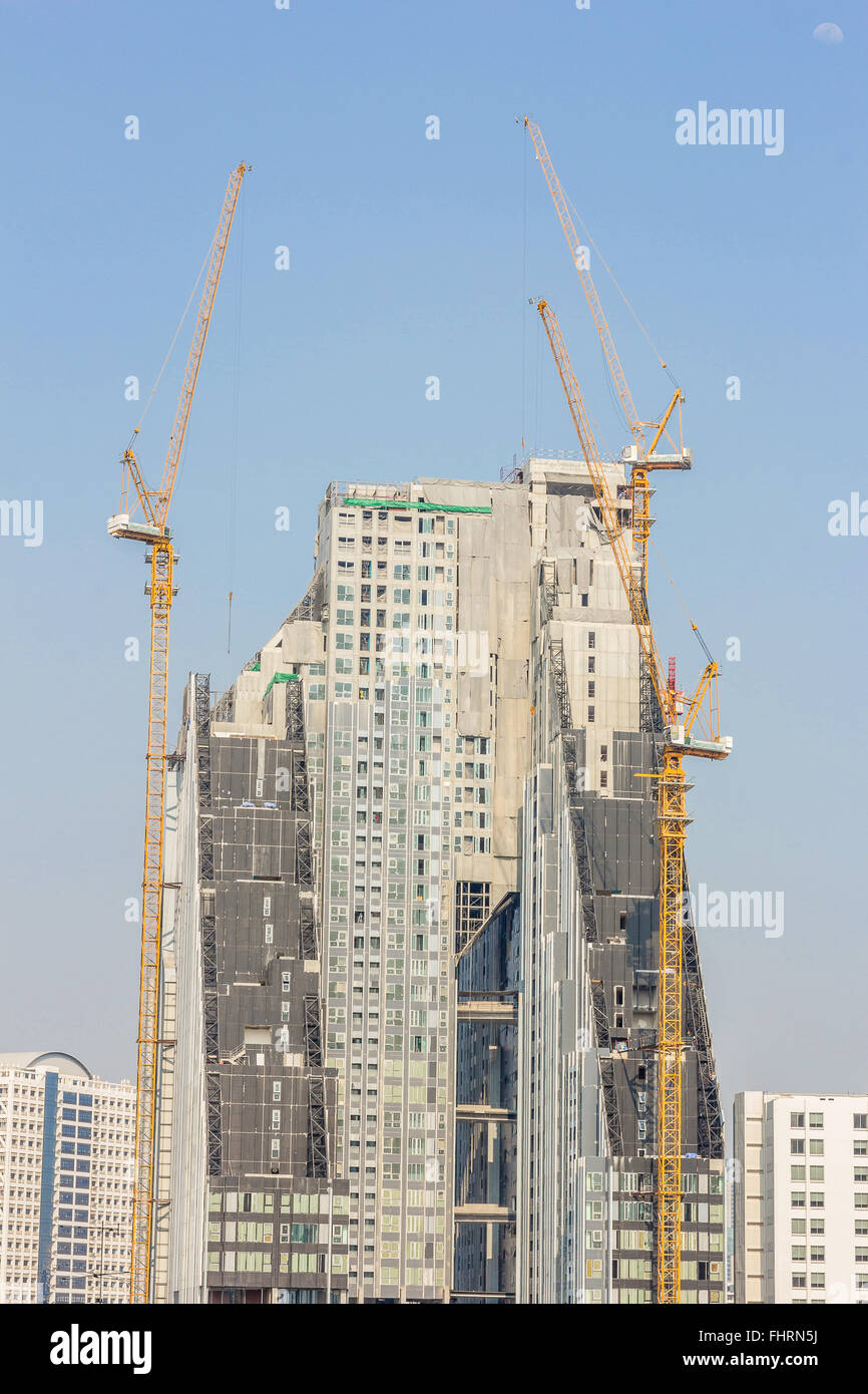 Inside place for many tall buildings under construction and cranes under a blue sky Stock Photo