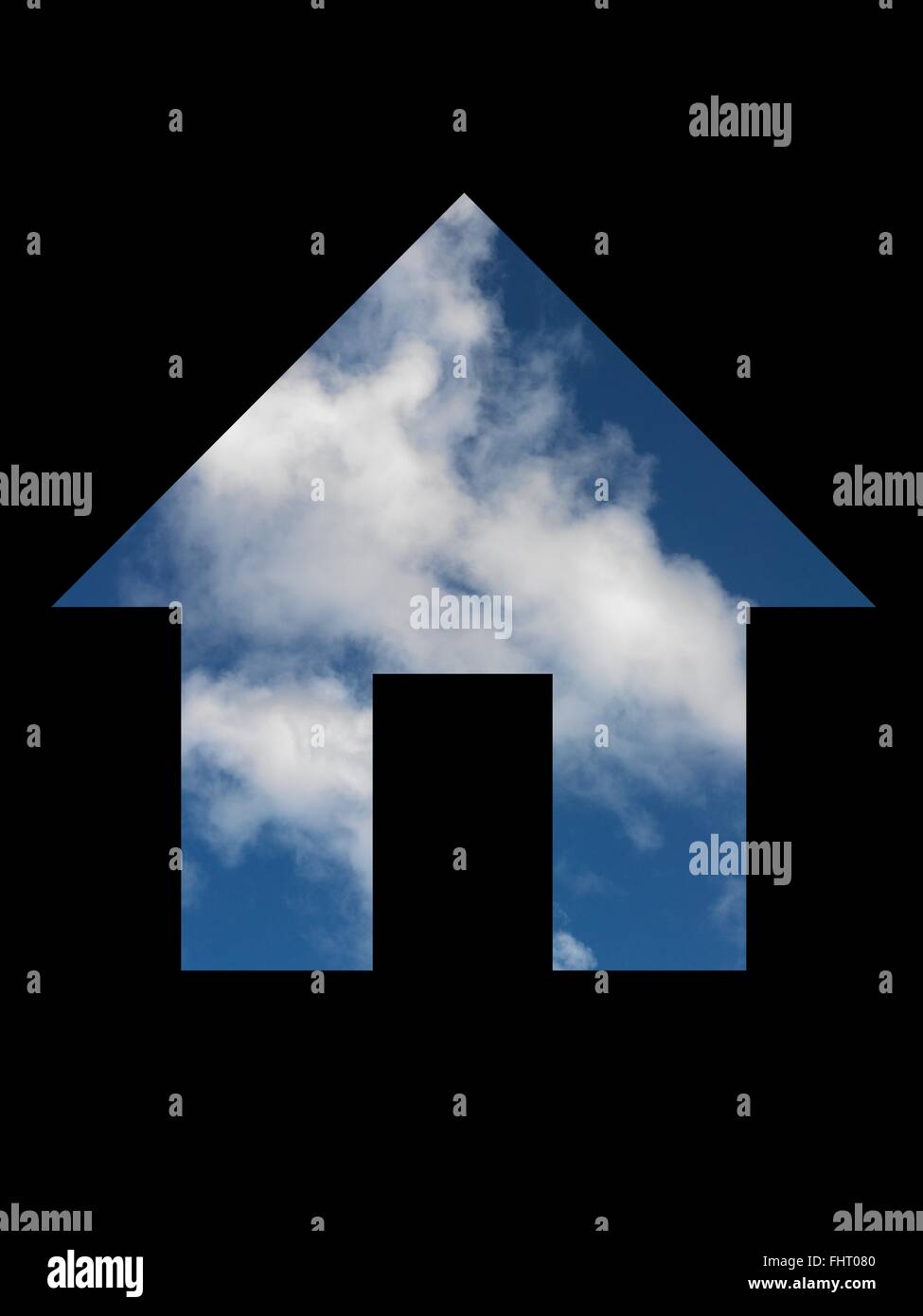 A house symol cut out with a blue sky Stock Photo