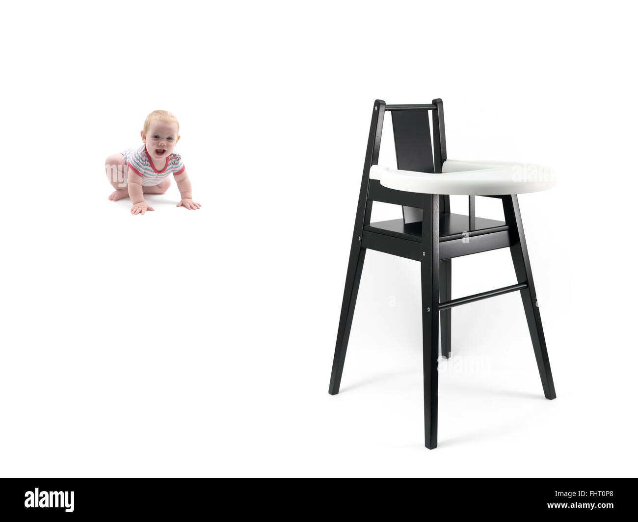 A small baby girl and a high chair Stock Photo Alamy