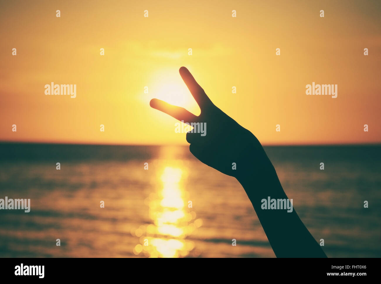 Silhouette of hand with victory sign with vintage and vignette effect Stock Photo