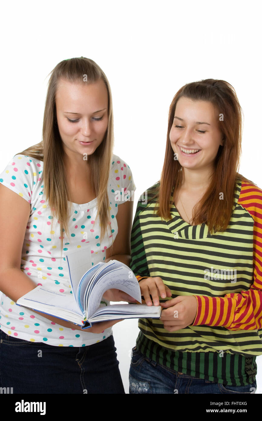 Two teenage girls smiling and reading book Stock Photo