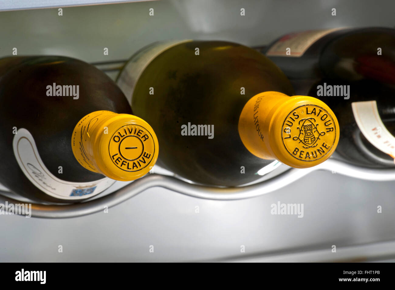 Burgundy white wine encapsulated bottle tops of Olivier Leflaive & Louis Latour white Burgundy wines in temperature controlled cabinet Stock Photo