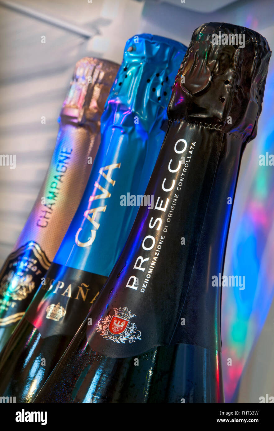 PROSECCO CAVA CHAMPAGNE Chilled sparkling wines in domestic refrigerator door Prosecco bottle in foreground Cava & Champagne behind in party lighting Stock Photo