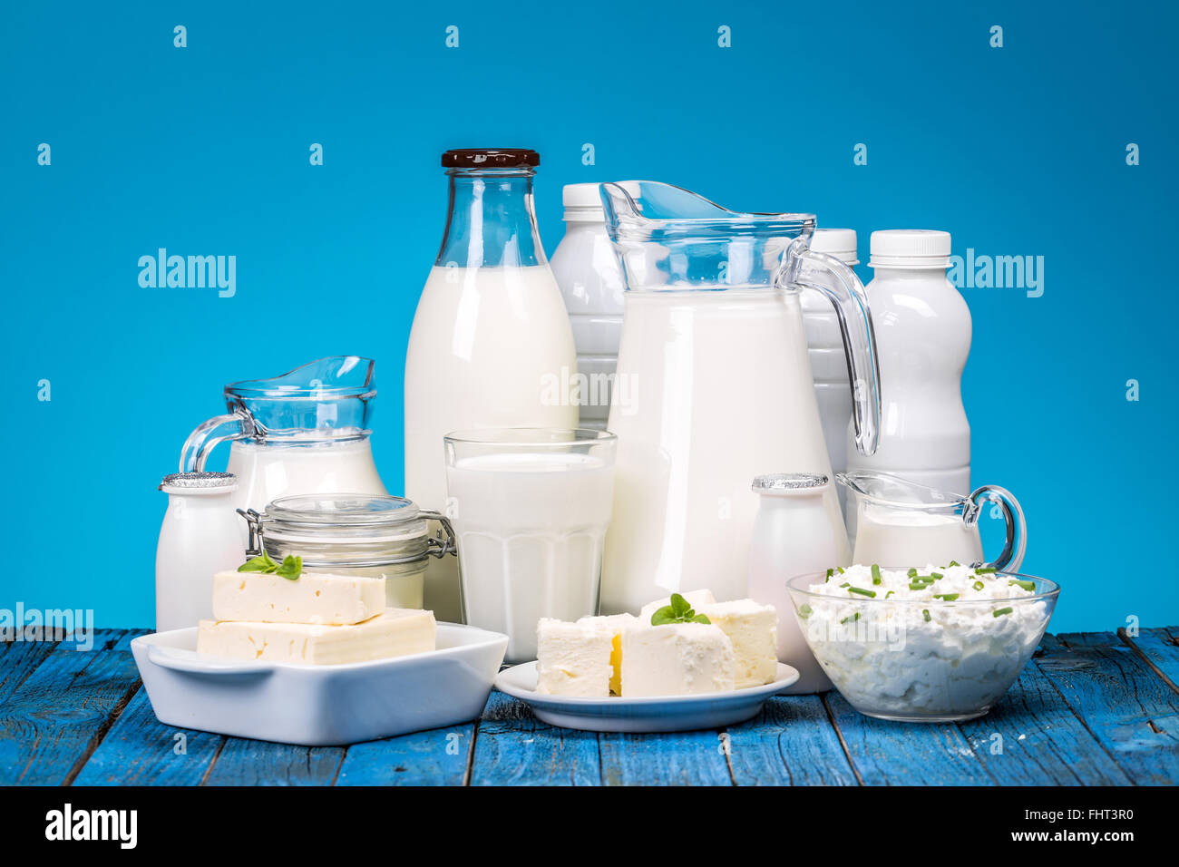 Dairy products on painted wooden table over blue background Stock Photo