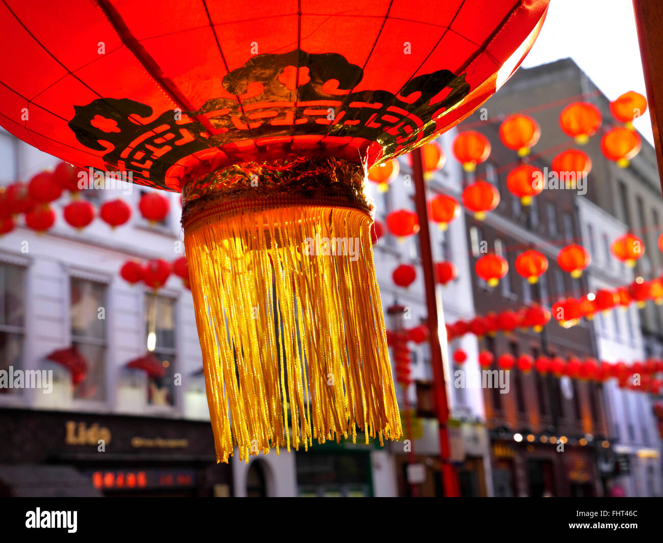 Traditional red Chinese lantern lit up at sunset outside a Chinese restaurant in Chinatown Soho London UK Stock Photo