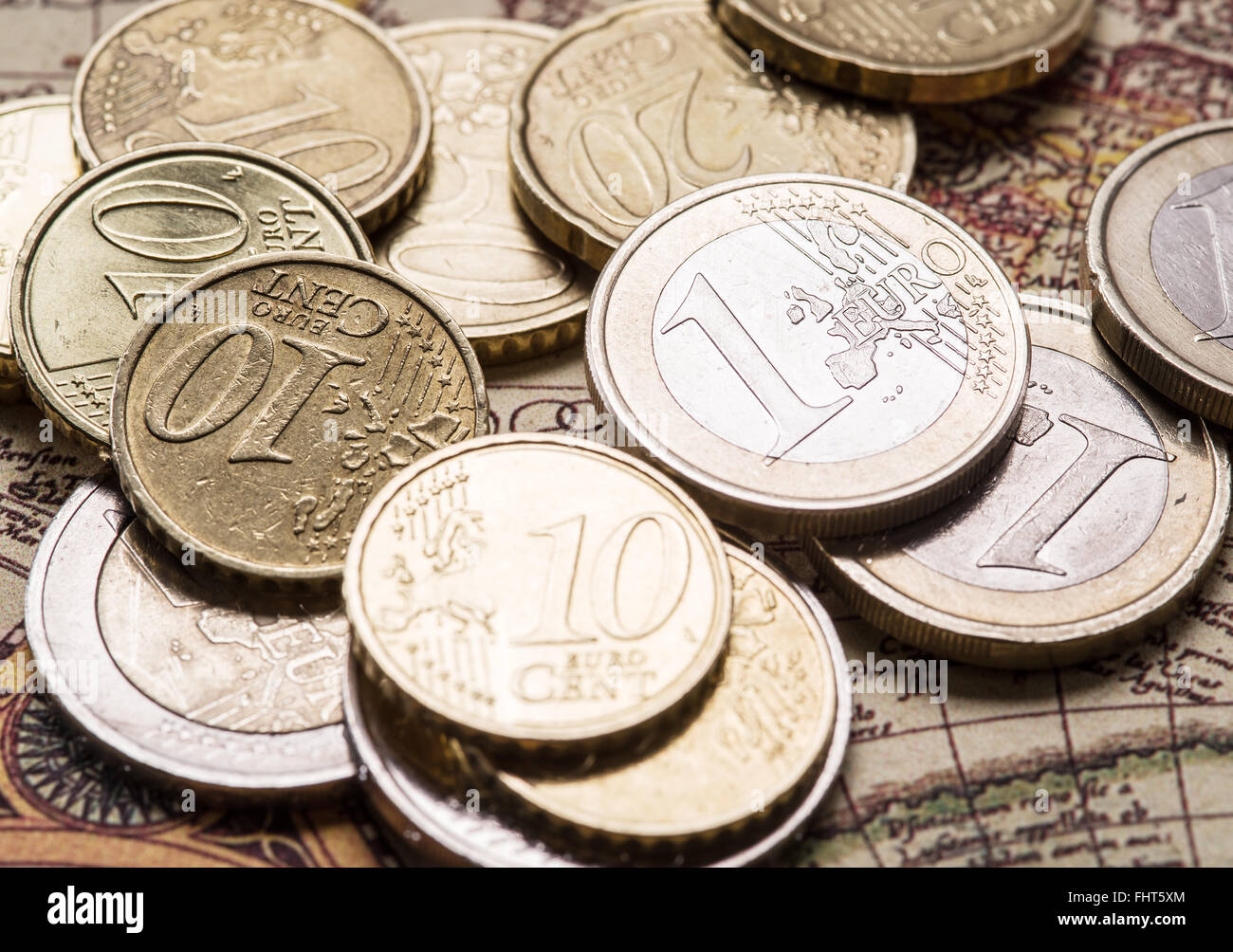 Euro coins over the old world map. Macro picture. Stock Photo